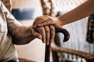 close-up of two hands on a walking cane